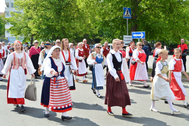 Iloisia ilmeita Karjalaisten kesäjuhlien juhlakulkueessa.